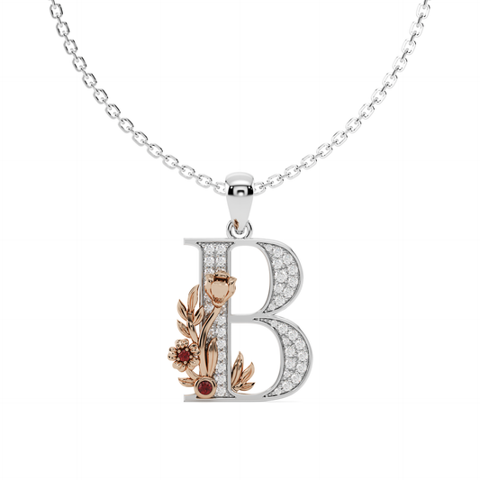 A hand-crafted white gold letter B pendant, entwined with a rose gold floral vine featuring pavé diamonds and a vivid gem quality ruby colour stone.