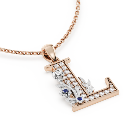 Handcrafted white gold letter L initial pendant from the Everbloom collection, set with diamonds and a rose gold floral motif featuring a round Blue sapphire gemstone.
